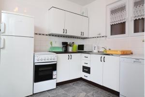 a white kitchen with white cabinets and appliances at Apartment Gea in Opatija +7 photos