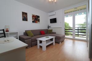 ein Wohnzimmer mit einem Sofa und einem Tisch in der Unterkunft Apartment Gea in Opatija
