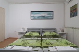 a bedroom with a bed with green comforter at Apartment Gea in Opatija