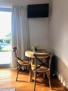 einen Tisch und zwei Stühle in einem Zimmer mit Fenster in der Unterkunft Wairimu View Lodge in Waipu