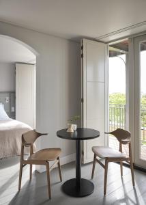 una camera da letto con un tavolo, due sedie e un letto di Boutique Hotel Benedict Noordwijk a Noordwijk aan Zee