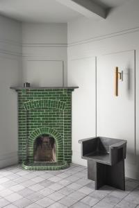 - une cheminée en brique verte dans une pièce avec lavabo dans l'établissement Boutique Hotel Benedict Noordwijk, à Noordwijk aan Zee