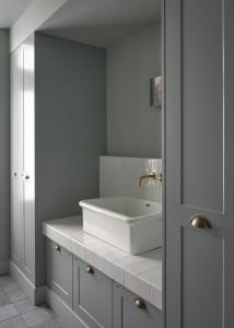 a bathroom with a white sink and a mirror at Boutique Hotel Benedict Noordwijk in Noordwijk aan Zee
