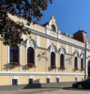 um edifício com janelas e flores ao lado em Tinódi Fogadó em Sárvár