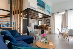 a living room with a blue couch and a table at Allure Luxury Villas 3&4 Serenity Retreat in Skiathos