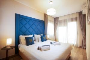a bedroom with a large bed with a blue headboard at Royal Bay in Dobra Voda +30 photos