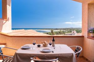a table with glasses of wine and a view of the ocean at Villa Laura in Villaputzu