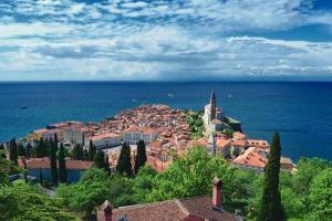 a town on a hill near the ocean at Unique spacious apartment with terrace in Piran