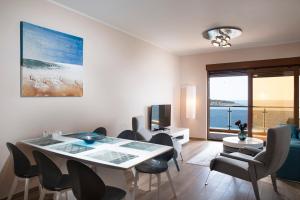 a living room with a dining room table and chairs at Royal Bay in Dobra Voda