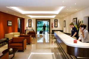 a lobby of a hotel with people standing at a counter at Hotel Provincial in Sierra de la Ventana