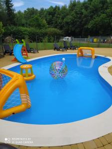 a large swimming pool with several different types of play equipment at Apartament Dominikana in Sianozety