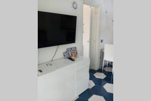 a living room with a tv on a white wall at Villa Cilento Mare, bellissima con ampio giardino in Capitello