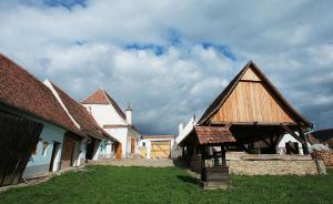 a group of buildings with roofs and a church at La Hansi in Crit in Criţ