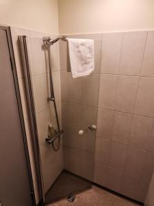 kabinę prysznicową z ręcznikiem wiszącym na ścianie w obiekcie Hotel Mikligardur w mieście Sauðárkrókur