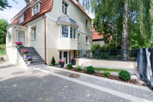 a white house with a fence and stairs at Apartamenty na Uphagena in Gdańsk