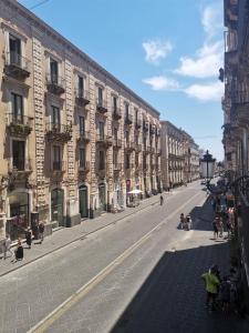an empty city street with buildings and people walking on the street at Agata dreams apartment in Catania