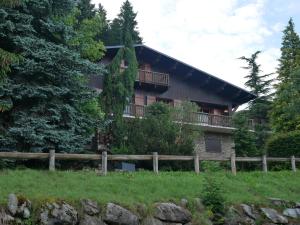 une maison avec une clôture devant elle dans l'établissement Chalet Horizon Blanc, à Megève