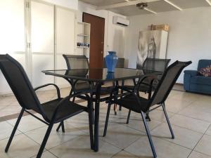 een eettafel met zwarte stoelen en een blauwe vaas erop bij Sealoft in Isola delle Femmine