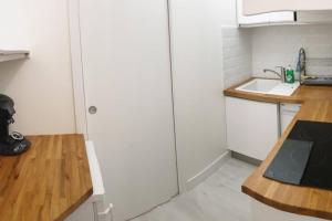 eine Küche mit einem weißen Kühlschrank und einer Holztheke in der Unterkunft HanaHome 2 adultes parking privé business & tourisme in Le Chesnay