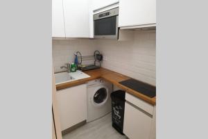 eine kleine Küche mit Spüle und Waschmaschine in der Unterkunft HanaHome 2 adultes parking privé business & tourisme in Le Chesnay
