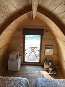 um quarto no sótão com uma cama e uma janela em Camping & Glamping Muiñeira em O Grove