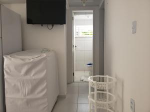 a kitchen with a white refrigerator and a window at Apartamento na Praia do MORRO BRANCO - CEARÁ - MB06201 in Beberibe
