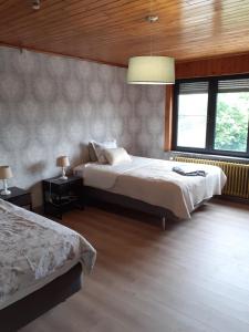 1 dormitorio con 2 camas y ventana grande en Wenceslas Cobergher Penthouse en Boutersem