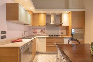a kitchen with wooden cabinets and a counter top at B&B Casa Dodo Luxury in Forlì