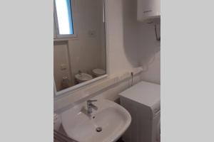 ein weißes Badezimmer mit einem Waschbecken und einem Spiegel in der Unterkunft Dalla Bosh 2 in Parma