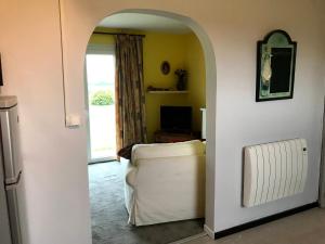 a living room with a white couch and a window at Le Cottage in Vinax