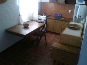 una pequeña cocina con mesa de madera y nevera. en Cabañas Las Lunas, en La Pedrera