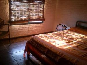 1 dormitorio con cama, ventana y silla en Cabañas Las Lunas, en La Pedrera