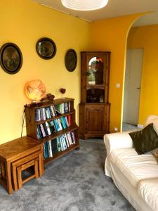 a living room with a couch and a book shelf with books at Le Cottage in Vinax