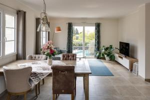 un soggiorno con tavolo da pranzo e un soggiorno con divano. di Luxurious and spacious apartment in the heart of the Côte d'Azur a Roquefort-les-Pins