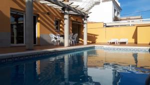 a swimming pool with chairs and a house at SANT BRIU in L'Escala