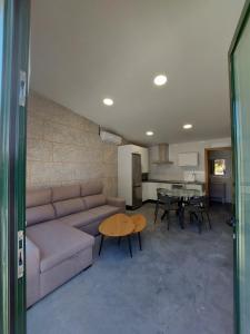 ein Wohnzimmer mit einem Sofa und einem Tisch in der Unterkunft Precioso apartamento vacaciones en zona Ramallosa in Baiona