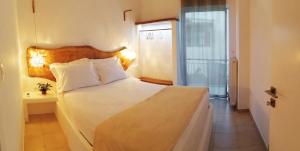 Un dormitorio con una gran cama blanca y una ventana en Elia Luxury Apartment, en Eretria