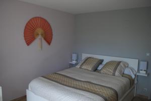 a bedroom with a bed with a fan on the wall at Résidence Bellevue in Pontacq