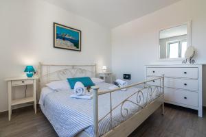 a bedroom with a bed and a dresser at Apartments Garden in Baška