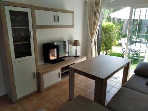a living room with a tv and a table at Playa Golf IV in Islantilla