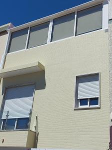 um edifício com duas janelas com persianas em CASA BIA em Portimão