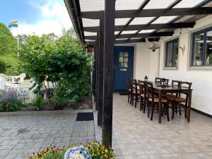 a patio with a wooden pergola and a table and chairs at 4hearts b&b in Sölvesborg