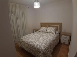 a bedroom with a bed and a chandelier at Playa Golf IV in Islantilla