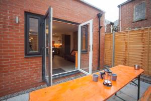 a patio with a wooden table in front of a brick building at higgihaus #3a & 3b 8 Bed Sleeps up to 22 Big Groups Hip Location in Bristol
