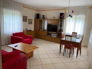 PisanoにあるVilla Vacanzeのリビングルーム(赤いソファ、テーブル付)