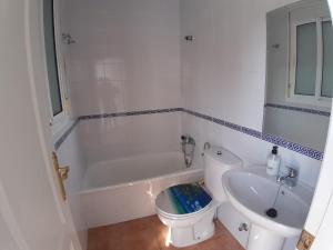 a bathroom with a toilet and a tub and a sink at Playa Golf IV in Islantilla +15 photos