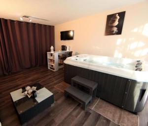 a bathroom with a large tub with a table and a table at Jac-Cosy in Fleurier