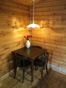 una mesa y sillas en una habitación con paredes de madera en Heidi Cabin, en Reykholt