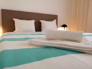 a bed with white blankets and pillows on it at Casa do Quico in Nazaré