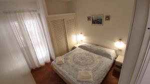 a small bedroom with a bed and a window at Casa Gialla in Costa Paradiso